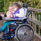 Child in a wheelchair receiving support services by the NDIS  